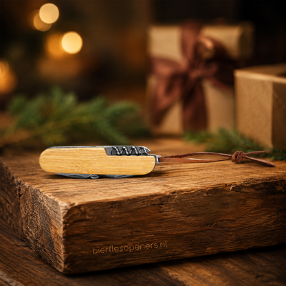 Bamboe zakmes met leren koord als cadeau op rustiek houten plank met kerstversiering op de achtergrond